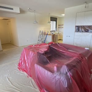 חדר עם כיסוי פלסטיק אדום, סולם וכלי צביעה