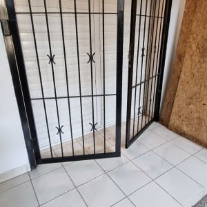 דלת ברזל עם סורגים על רצפת אריחים