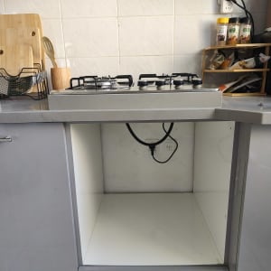 תמונה של מטבח עם כיריים וארון פתוח