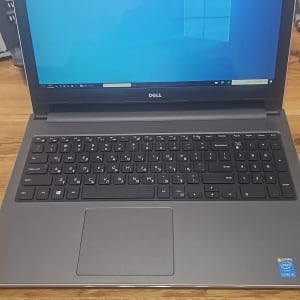 מחשב נייד דל עם מסך פתוח על שולחן עץ