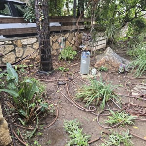 מערכת השקיה בגינה עם צינורות ומיכל מים