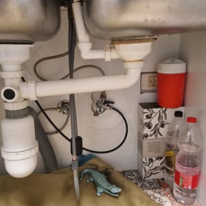 צנרת מתחת לכיור עם חפצים שונים