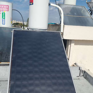 דוד שמש עם קולטים על גג תחת שמיים מעוננים