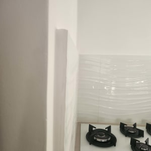 כיריים גז מותקנים על משטח במטבח עם קיר אריחים לבנים