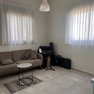 וילונות לבנים תלויים בחדר עם ספה ושולחן קטן