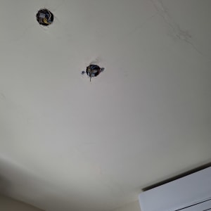 שני חורים בתקרה עם חוטי חשמל חשופים