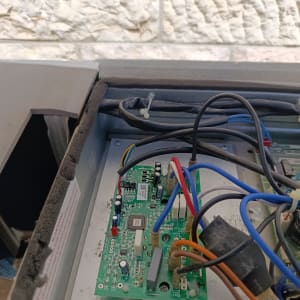 מעגל חשמלי עם חוטים צבעוניים בתוך יחידת מיזוג אוויר