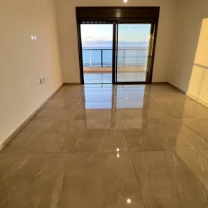 רצפה מבריקה עם נוף לים דרך חלון גדול