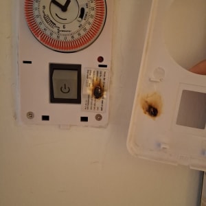 שעון טיימר עם סימני שריפה על הקיר