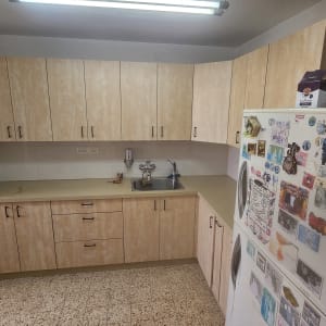 מטבח עם ארונות עץ, כיור וברז, מברג על השיש