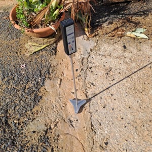 מכשיר איתור נזילות על קרקע ליד עציץ