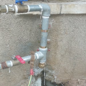 צינורות מתכת עם ברזים על קיר חיצוני