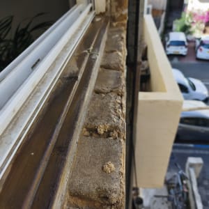 אדן חלון עם לבנים ישנות ומסגרת עץ