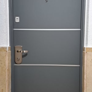 דלת אפורה עם ידית מתכת ופסים אופקיים