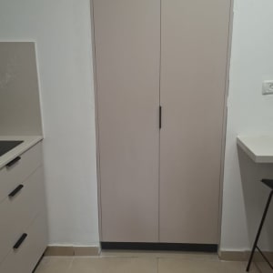 ארון מטבח עם דלתות סגורות ומגירות בצד