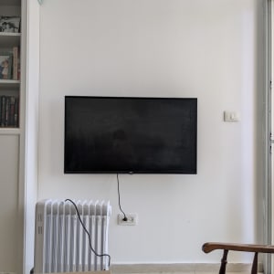 טלוויזיה תלויה על קיר ליד רדיאטור