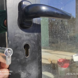 מנעול וצילינדר בדלת זכוכית עם ידית שחורה