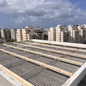 גג עץ עם מבנה מתכת ונוף עירוני ברקע