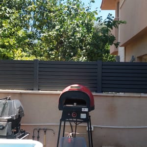 גדר אלומיניום הייטק בגוון אפור אנתרציט בחצר בית