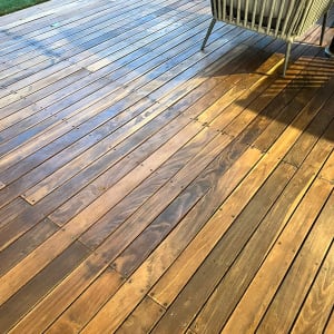 דק עץ עם כיסא גינה על משטח עץ