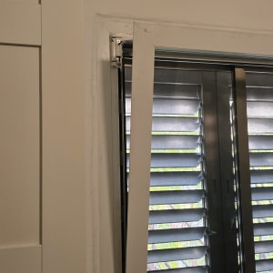 תריסים פתוחים למחצה עם מסגרת חלון לבנה