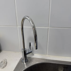 ברז מים מותקן על כיור מטבח עם אריחי קרמיקה