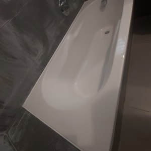 אמבטיה לבנה עם אריחים כהים מסביב