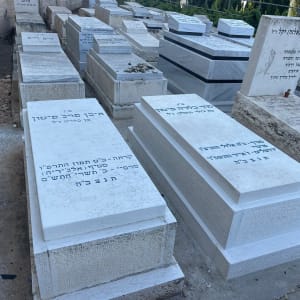 מצבות לבנות עם כיתוב בעברית בבית קברות