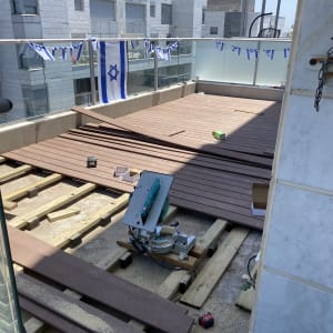 עבודת התקנת דק עץ עם מסור חשמלי וכלים נוספים