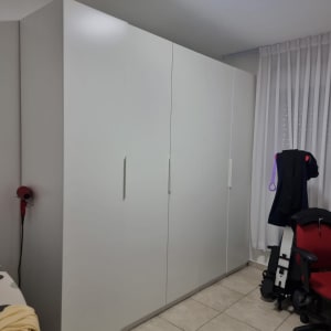 ארון לבן בחדר עם כיסא אדום