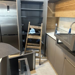 סולם עץ ומטלית כחולה בארון פתוח במטבח