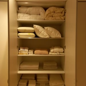 ארון עם מצעים מקופלים ומסודרים על מדפים