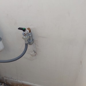 ברז מים מותקן על קיר עם צינור מחובר