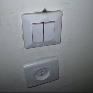 שקע ומתג חשמל על קיר לבן