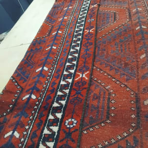 שטיח אדום עם דוגמאות גיאומטריות על שולחן