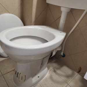 אסלה לבנה בחדר שירותים עם אריחים