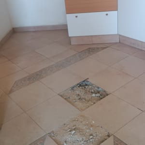 רצפה עם אריחים חסרים ועבודת תיקון