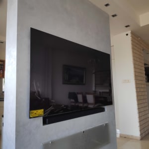 טלוויזיה מותקנת על קיר בסלון ביתי