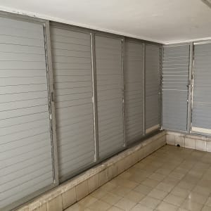 רצפה נקייה עם אריחים ליד תריסים אפורים