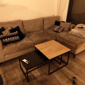 ספה אפורה עם כריות ודברים על השולחן