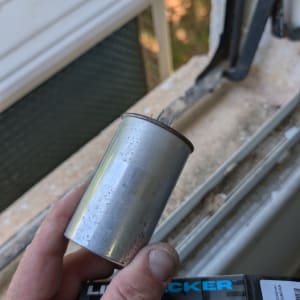 יד מחזיקה קבל ליד חלון עם מזגן