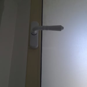 ידית חלון לבנה על מסגרת חלון