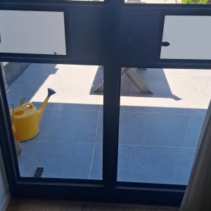 חלון זכוכית עם נוף לחצר ומזלף צהוב