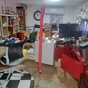 חדר עבודה מבולגן עם שולחנות, כיסאות ומדפים