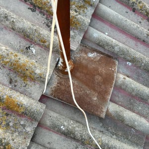 תמונה של גג עם חוטים ומוט מתכת חלוד