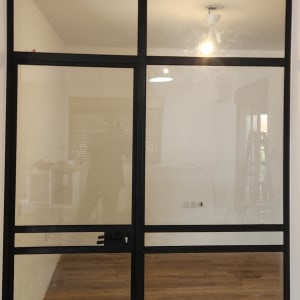 דלת זכוכית עם מסגרת מתכת בחדר משופץ