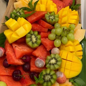 מגש פירות טריים עם אבטיח, מנגו, קיווי וענבים