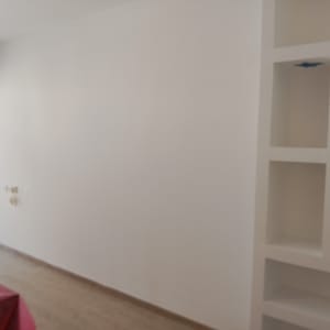 קיר לבן עם מדפים מובנים בחדר ריק