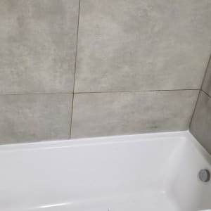 אמבטיה עם ברז מקלחת על קיר אריחים