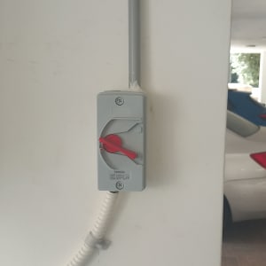 מתג חשמלי עם ידית אדומה על קיר לבן